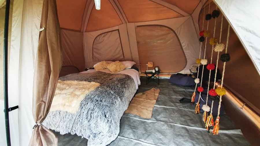 Luxury Inca Trail dining and lodging experience shown inside a premium sleeping tent with cozy beds and elegant details.